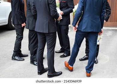 Group of young men in suits standing waiting for their prom date - Shutterstock ID 2143346939
