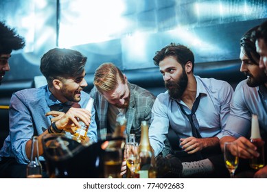 Group Of Young Men Talking In A Bar, Drinking Beer