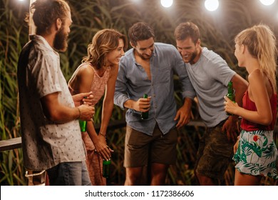 Group Of Young Men And Women Laughing At At Outdoor Summer Party.