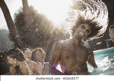 A group of young men and women in the swimming pool at the end of a hot day - Shutterstock ID 602618177