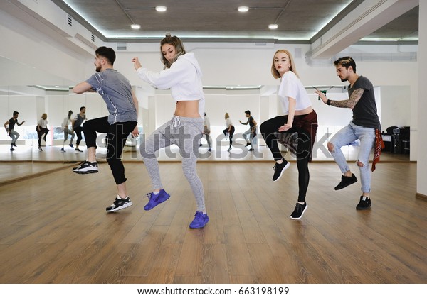 Group of young modern dancers\
dancing in the studio. Sport, dancing and urban culture\
concept