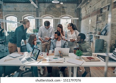 Group of young modern people in smart casual wear communicating and using modern technologies while working in the office                - Shutterstock ID 1511797076