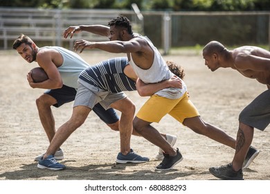 group of young multicultural men playing football on court