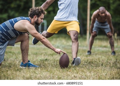 group of young multicultural men playing football on court