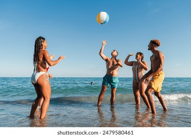 Group of young multiracial friends having fun at the beach, playing in the sea with an inflatable ball, and enjoying their summer vacation on the coast. Happy tourists having a good time at shore - Powered by Shutterstock