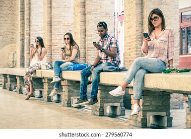 Group of young multiracial friends using smartphone with mutual disinterest towards each other - Technology addiction in actual lifestyle - Soft vintage filtered look with main focus on male person - Shutterstock ID 279560774