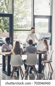 Group Of Young Multiracial People Working In Modern Light Office. Businessmen At Work During Meeting.