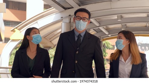 Group Of Young Office Business People Walking To Skytrain Station With New Normal Lifestyle. People Wearing Protective Face Mask To Prevent Covid Infection. Man And Woman Having Communication Together