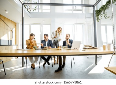 Group Of A Young Office Workers Eating Salads And Drinking Coffee At The Modern Office Canteen. Concept Of A Healthy Takeaway Food On The Work