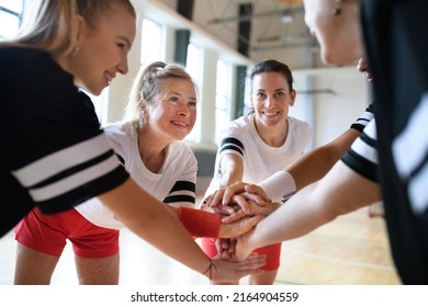 Group of young and old women in gym stacking hands together, sport team players. - Powered by Shutterstock