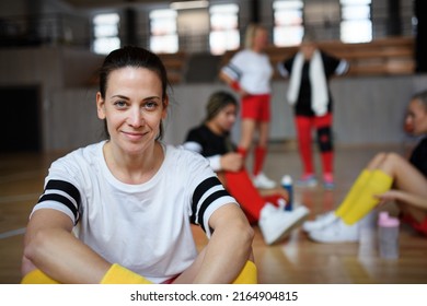 Group of young and old women, sports team players in gym sitting and resting after match. - Powered by Shutterstock