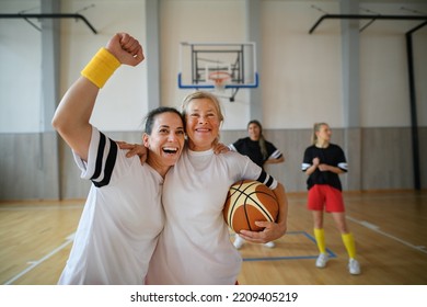 Group Of Young And Old Women, Sports Team Players, In Gym Celebrating Victory.