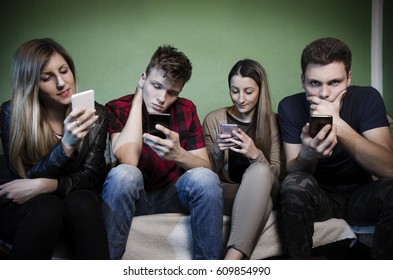 Group Of Young People Addicted To Smartphones, Anti Social Young People. Selective Focus On Teen In Red Shirt 