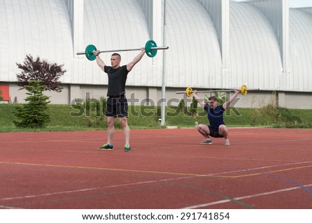A Group Of Young People In Aerobics Class Doing A Overhead Squat Exercise Outdoor