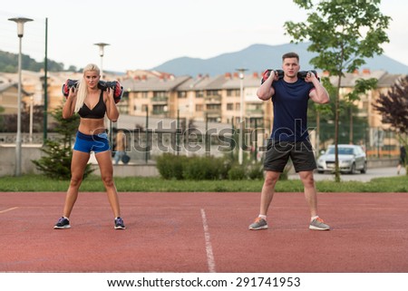 A Group Of Young People In Aerobics Class Performing Bag Squat Exercise Outdoor