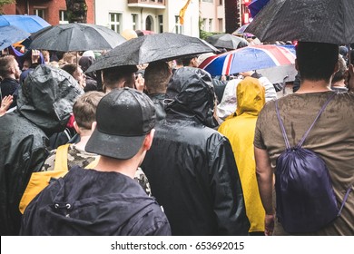 Group of young people from behind walking in rain  with umbrellas - Powered by Shutterstock