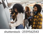 Group of young people buying train tickets at an automatic machine in a subway or train station, enjoying the travel and commuting experience together in an urban setting