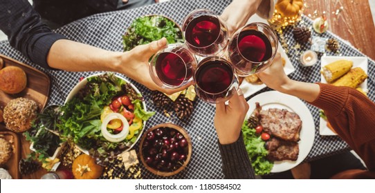 Group Of Young People Celebrating Christmas Thanksgiving Party Dinner With Clinking Glass Of Wine, Top View