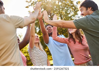 Group of young people celebrating success and togetherness with a high five in nature - Shutterstock ID 2191267321