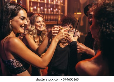 Group Of Young People With Cocktails At Nightclub. Best Friends Partying In A Pub And Toasting Drinks.