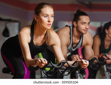 Group Of Young People Cycling In Class In Gym