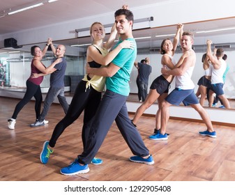 Group Of Young People Dancing Salsa Together In Dance Studio 