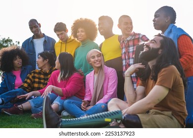 Group of young people from different cultures gathered in the park to share good times. Concept: Lifestyle, outdoors, multicultural - Powered by Shutterstock