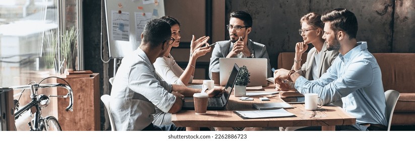 Group of young people discussing business while having meeting in the office - Powered by Shutterstock