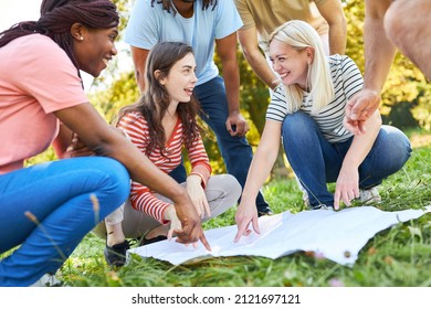 Group of young people doing geocaching as a scavenger hunt for teamwork and cooperation - Shutterstock ID 2121697121