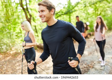 Group Of Young People Doing Nordic Walking As Endurance Training In Nature In Summer