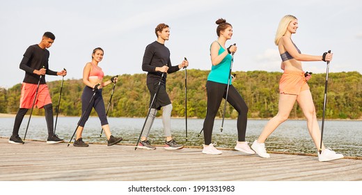 Group Of Young People Doing Nordic Walking For Fitness And Endurance In Nature