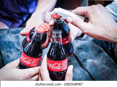 Group of young people drinking coke at a party. Coca Cola bottle Thailand, 5 May 2018