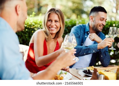 Group of young people enjoy lunch at a restaurant and drink wine - Shutterstock ID 2165566501