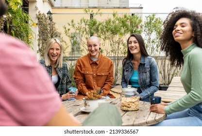 Group Of Young People Of Generation Z On The Terrace Of Youth Hostel Having Breakfast, Group Of Travelers Meeting People Of Different Cultures, Focus On The Bald Woman Smile