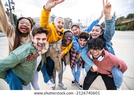 Group of young people with hands up looking at camera - Millenial friends having fun together on city street - Multicultural students walking outside university campus - Youth culture and scholarship