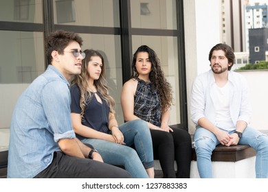 Group of young people having fun outside, chatting and laugthing in a relaxeded way