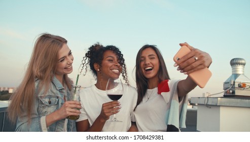 Group of young people having fun at a rooftop party, taking selfie