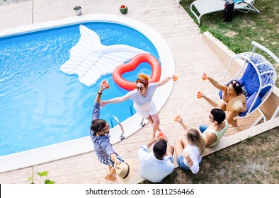 Group Of Young People Having Fun At Summer Vacation And Enjoying A Poolside Party With Drinks.