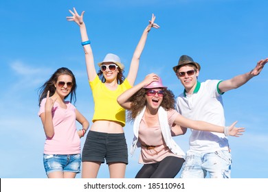 Group Of Young People Having Fun On A Blue Summer Sky