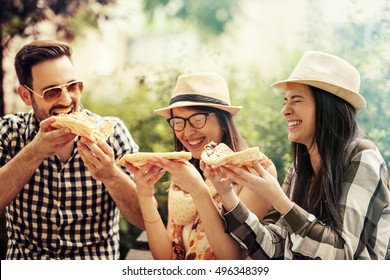 Group Of Young People Having Fun In The Park And Eating Pizza.