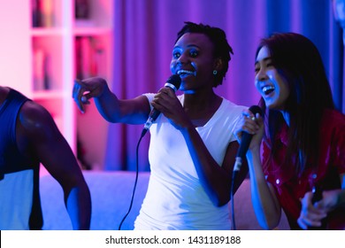 Group Of Young People Having A House Party Together. African American, Asian Man And Woman. Singing Together. Mix Race Party Concept.