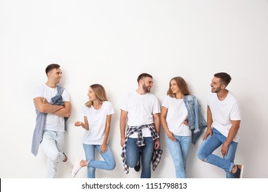 Group of young people in jeans on light background