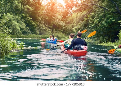 group of young people on kayak outing rafting down the river