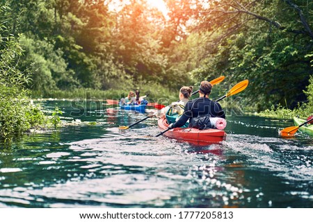 group of young people on kayak outing rafting down the river