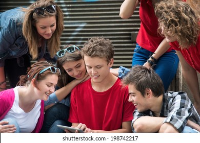 Gruppe junger Menschen, die Tablet-Spiele spielen