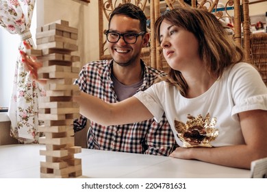 A Group Of Young People Playing Jenga Game On A Table At Home,man And Woman Close-up.Board Games Concept.Time Together.Stay Home Concept.Selective Focus.