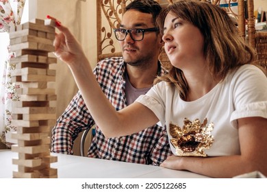 A Group Of Young People Playing Jenga Game On A Table At Home,man And Woman Close-up.Board Games Concept.Time Together.Stay Home Concept.Selective Focus.