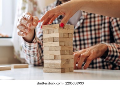 A Group Of Young People Playing Jenga Game On A Table At Home,hands Close Up.Board Games Concept.Time Together.Stay Home Concept.Selective Focus.