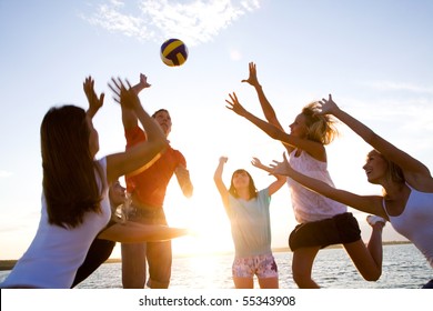 group of young people playing volleyball on the beach - Powered by Shutterstock