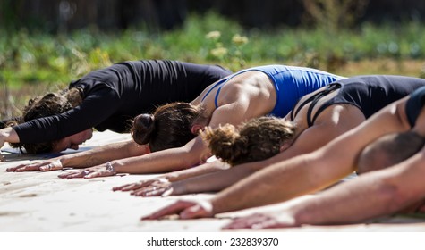 Group Of Young People Practicing In An Outdoor Yoga Class